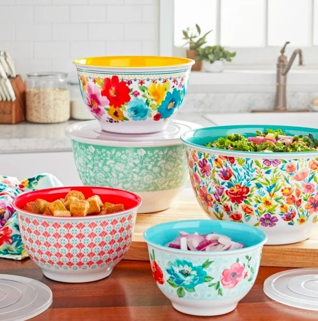 Five colorful bowls filled with salad ingredients sitting on a kitchen island