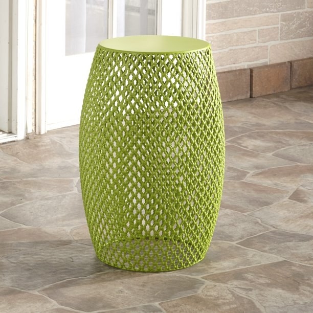Green outdoor stool on a stone floor