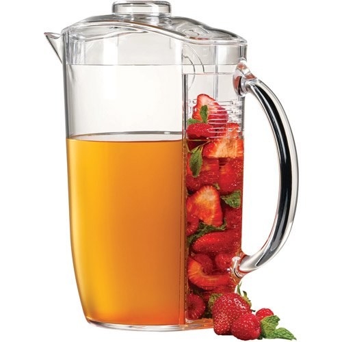 Pitcher filled with orange liquid and cut up strawberries and mint on the other side