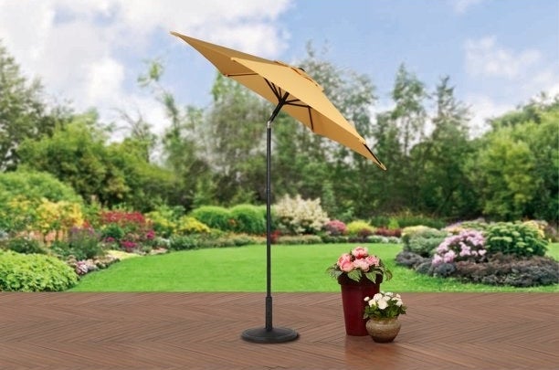 Yellow umbrella on a patio in a backyard