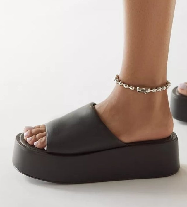 Person wearing platform slides with an anklet on