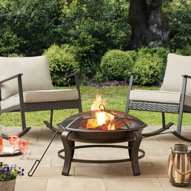 Fire pit on a patio with outdoor rocking chairs