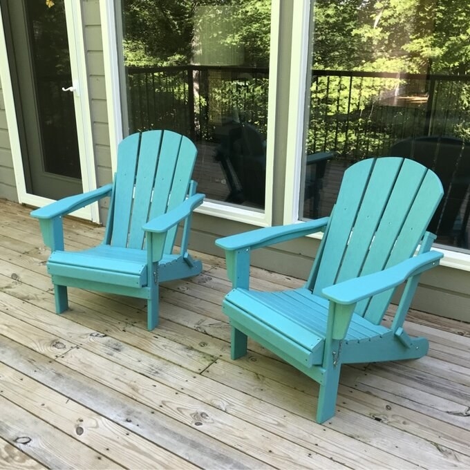 Two blue chairs with pillows in a reviewer&#x27;s backyard with a white pot in the center