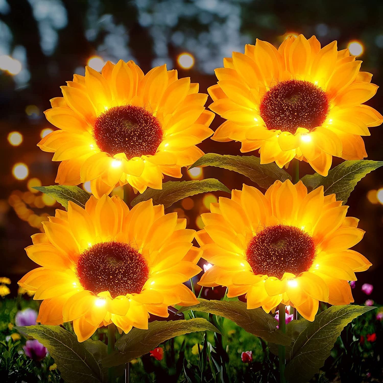 Four solar sunflower lights lit up in a garden at night