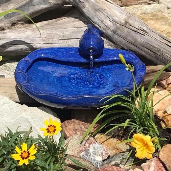 a reviewer photo of the blue fish water feature in a garden