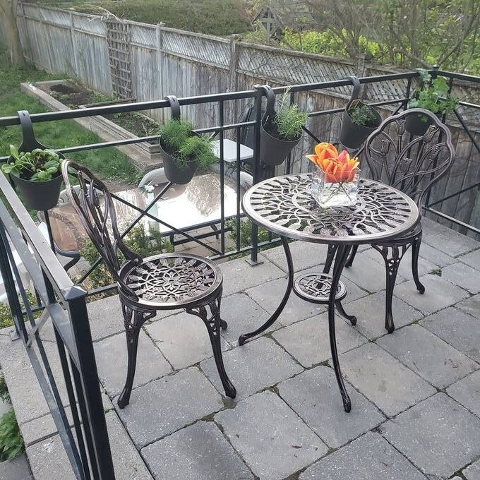 a reviewer photo of the bistro set on a backyard balcony
