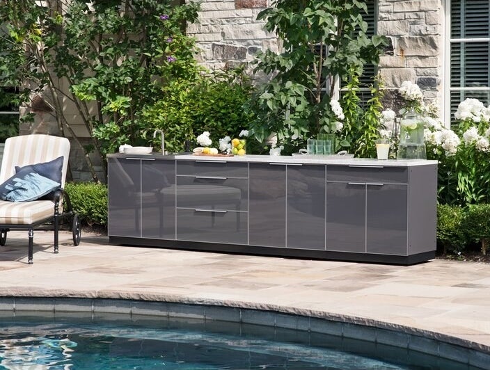 the shiny gray outdoor kitchen installed next to a pool