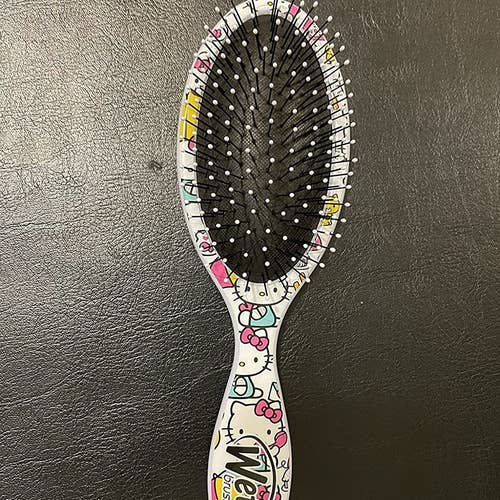 reviewer's photo of the hairbrush in Hello Kitty print