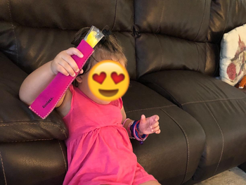 reviewer's photo of a child holding an ice pop in a pink sleeve