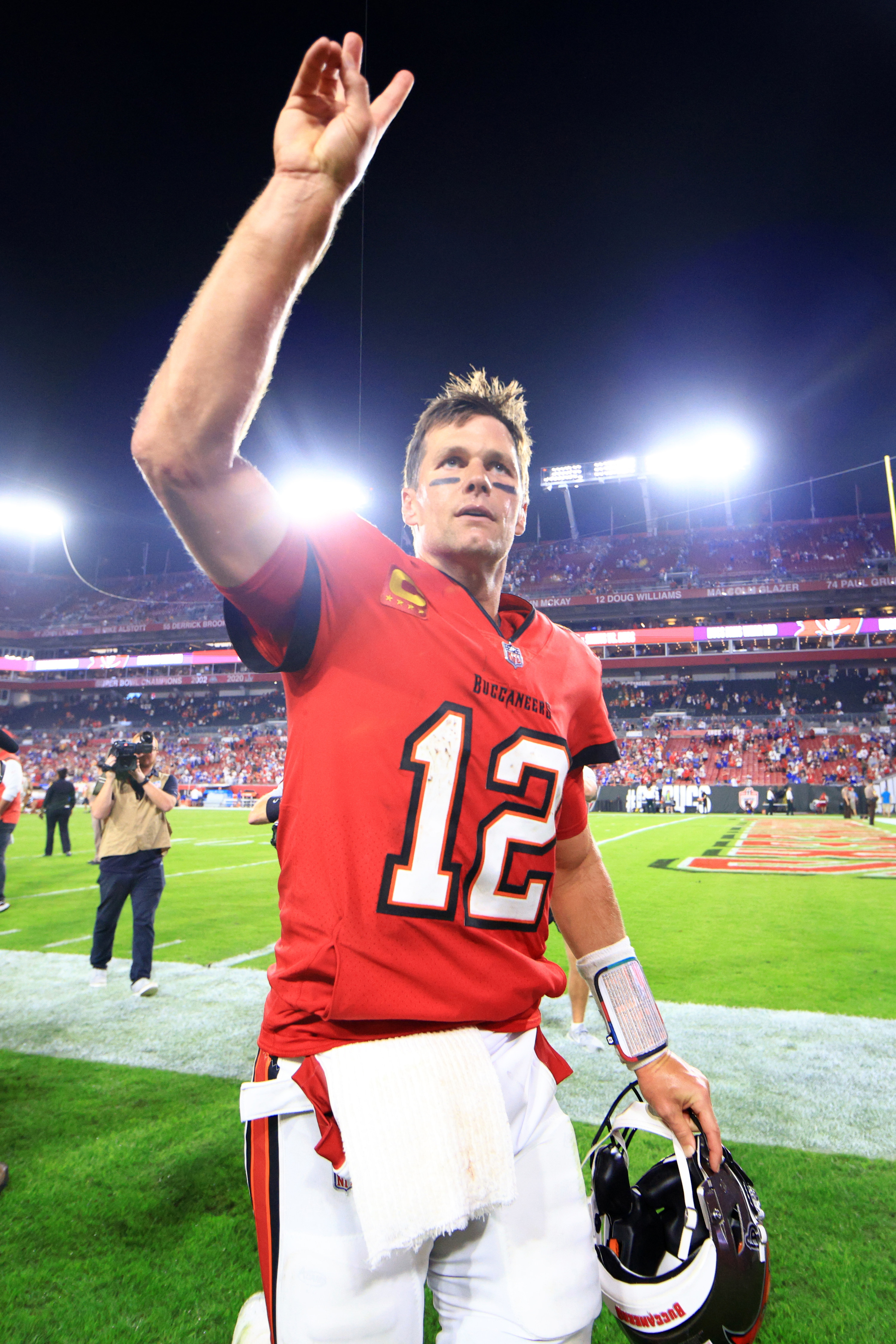 tom waving at fans from the field