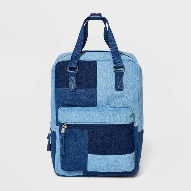 The backpack has a denim patchwork pattern