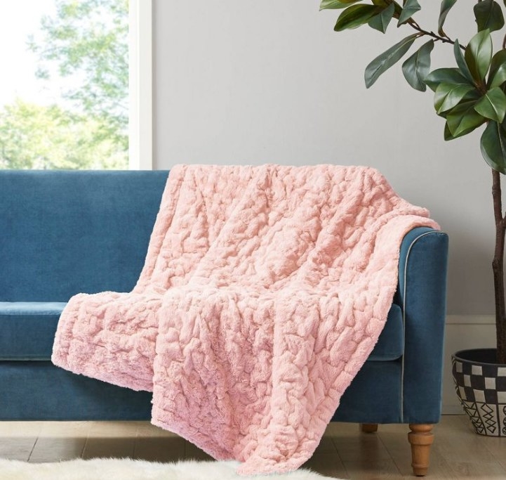Pink faux fur blanket on sofa