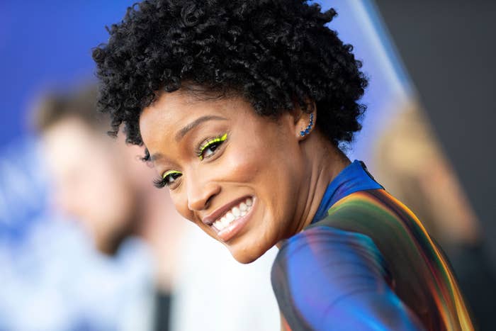 Keke Palmer wears a rainbow dress with lime green eyeliner and a curly afro