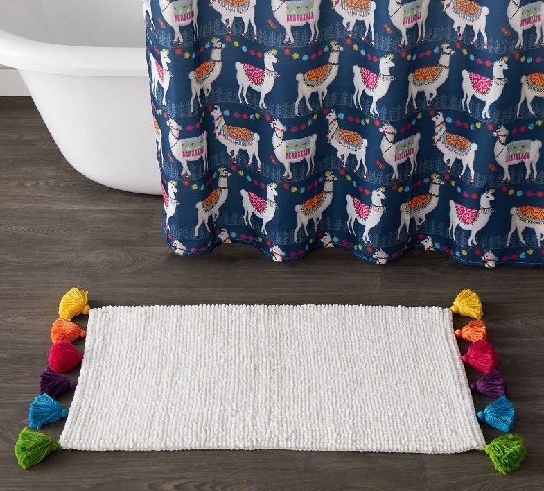 Bath rug with multicolored pom-poms