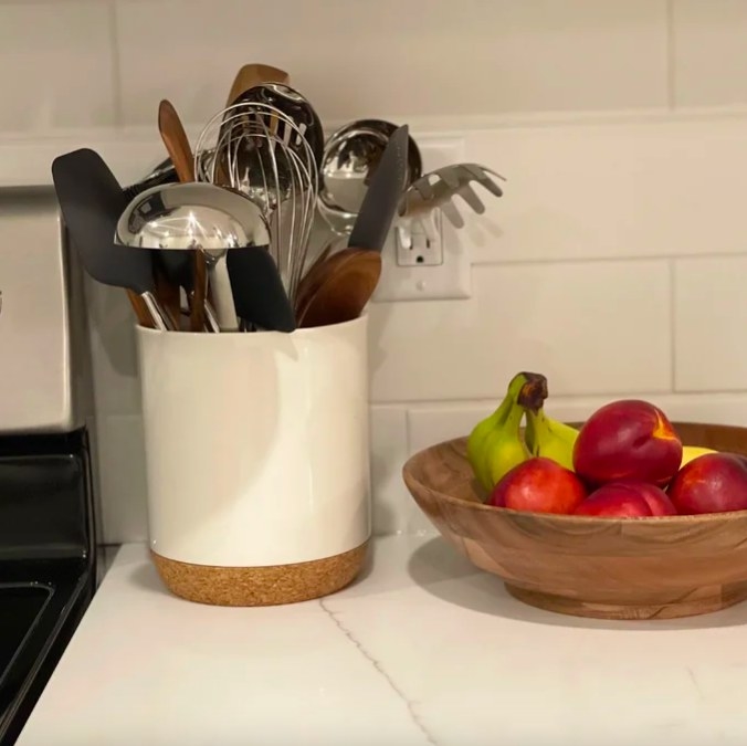 Reviewer image of crock filled with utensils next to a fruit bowl on a kitchen countertop