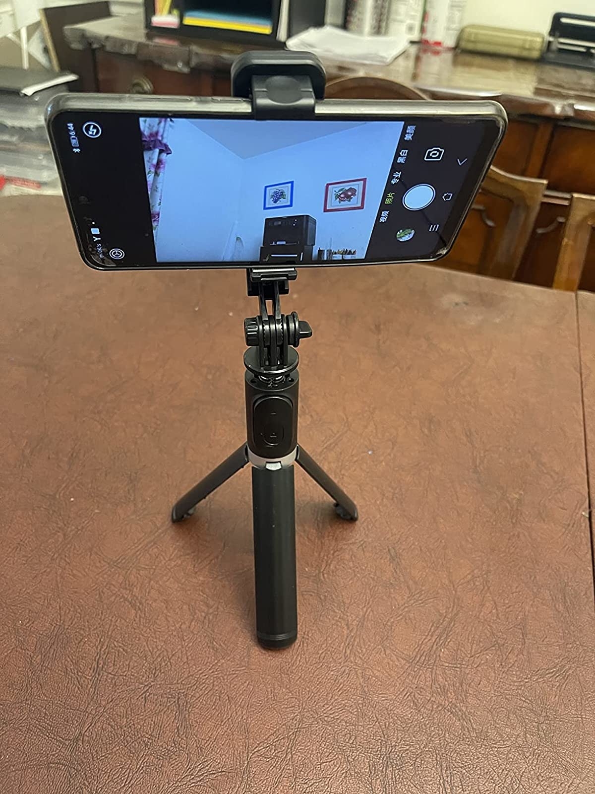 Reviewer&#x27;s photo of iphone secured in the tripod stand