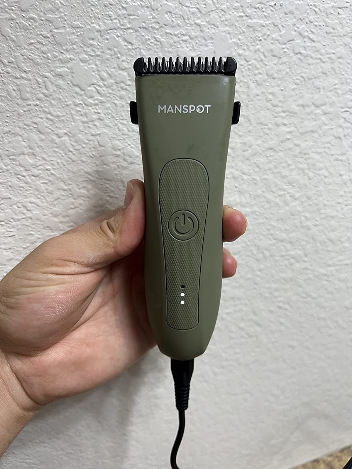 Reviewer holding the green electric trimmer