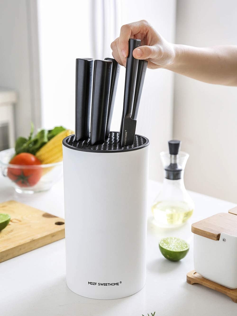 a person removing a knife from the universal knife block
