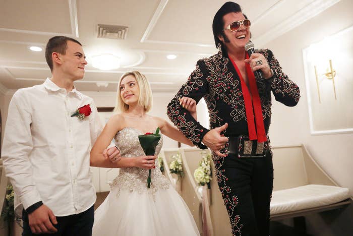 a couple walking down the aisle with an elvis impersonator