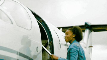 woman boarding a plane and waving