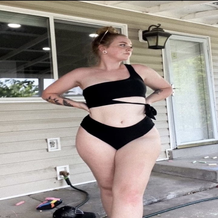 reviewer photo of them wearing a matching asymmetrical black bikini
