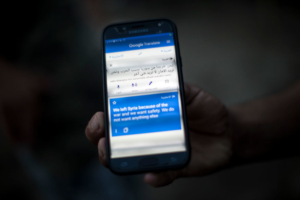 person holding a phone with a translation on the screen