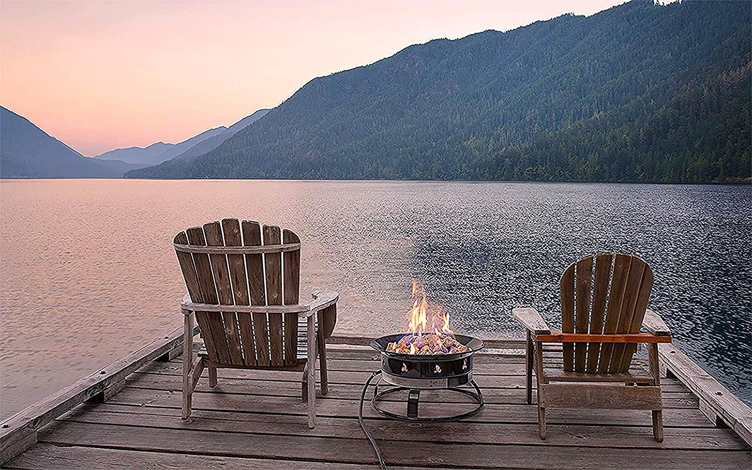 Fire pit on a dock by the lake in the middle of two chairs