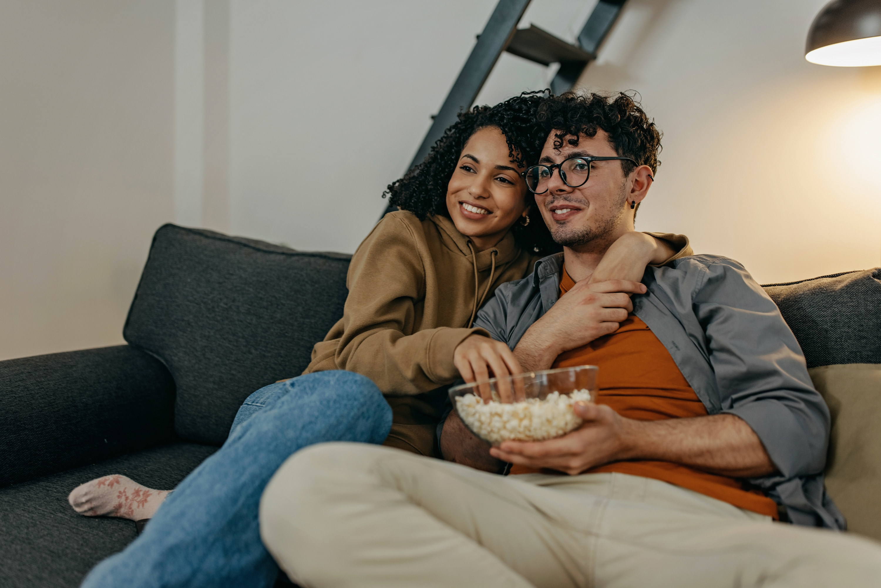 Young couple relaxing at home watching TV