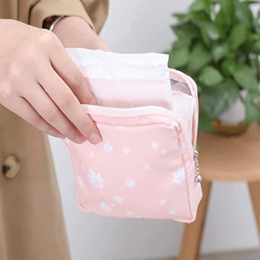 a person holding the pouch open with a pad inside
