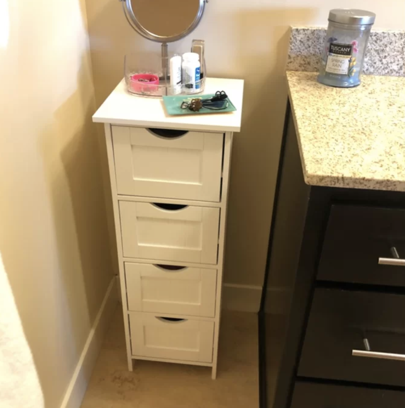 A freestanding white cabinet with four-drawers in a reviewer bathroom