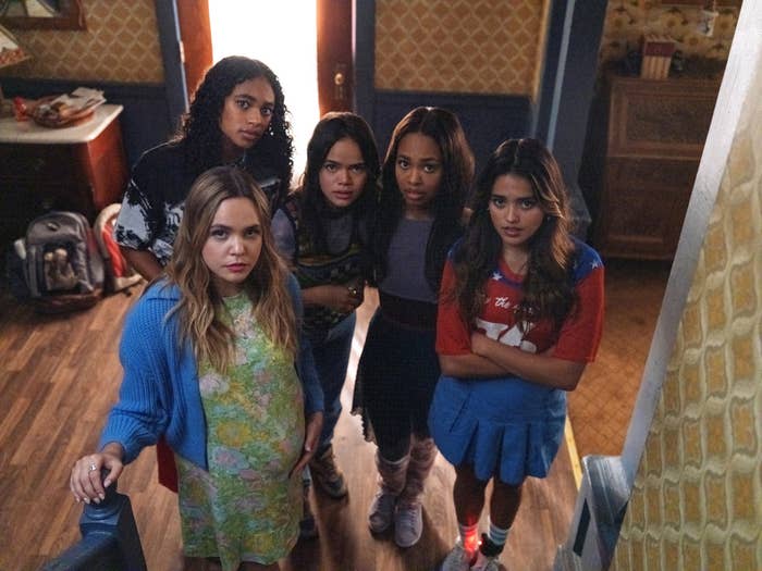 the Little Liars standing together in a room and looking up