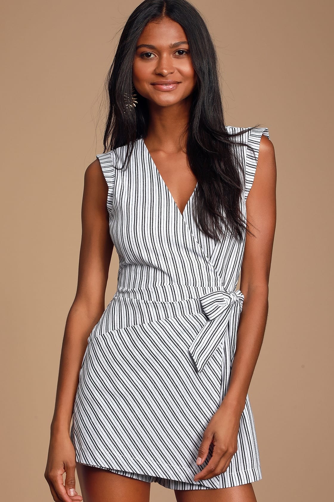 Model wearing black and white striped wrapped romper with tie in front