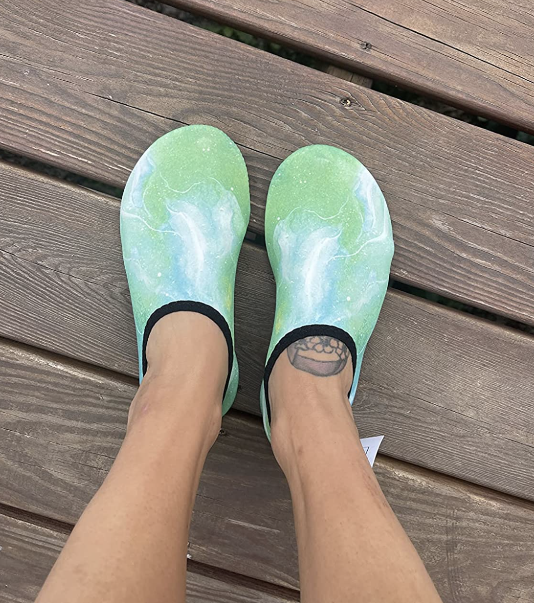 A reviewer with space dye white blue and green water shoes on their feet