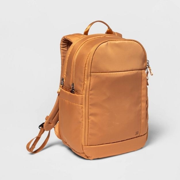 The backpack is a light brown and gold color