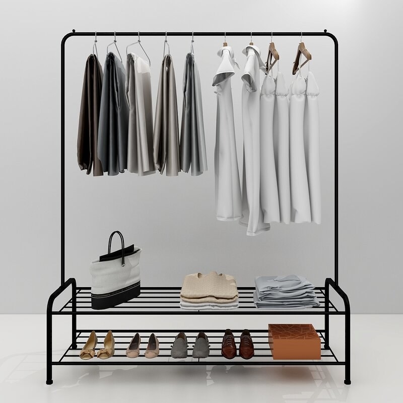 Black free standing clothing rack with clothes hanging and two shelves underneath with shoes on bottom shelf, and folded clothes and bag on upper shelf