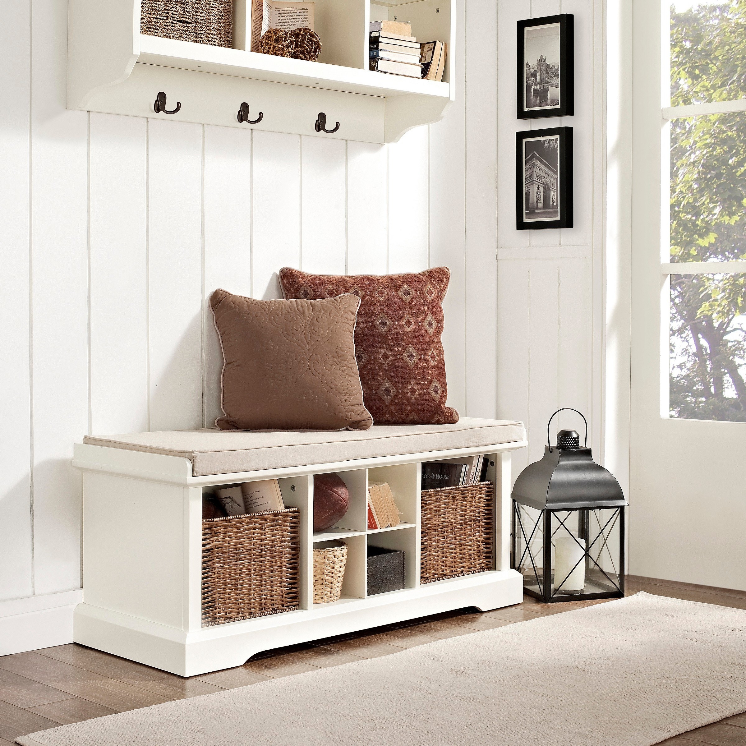 White entryway bench with rattan baskets in the shelves