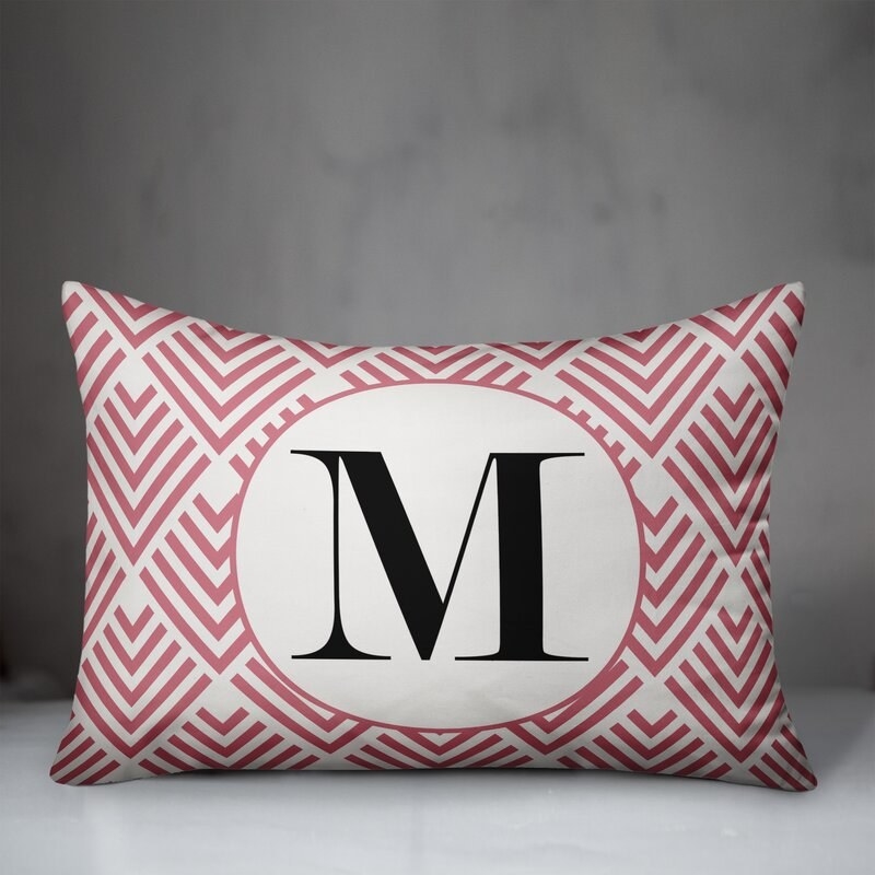 Pink and white tile patterned lumbar pillow with black M in center