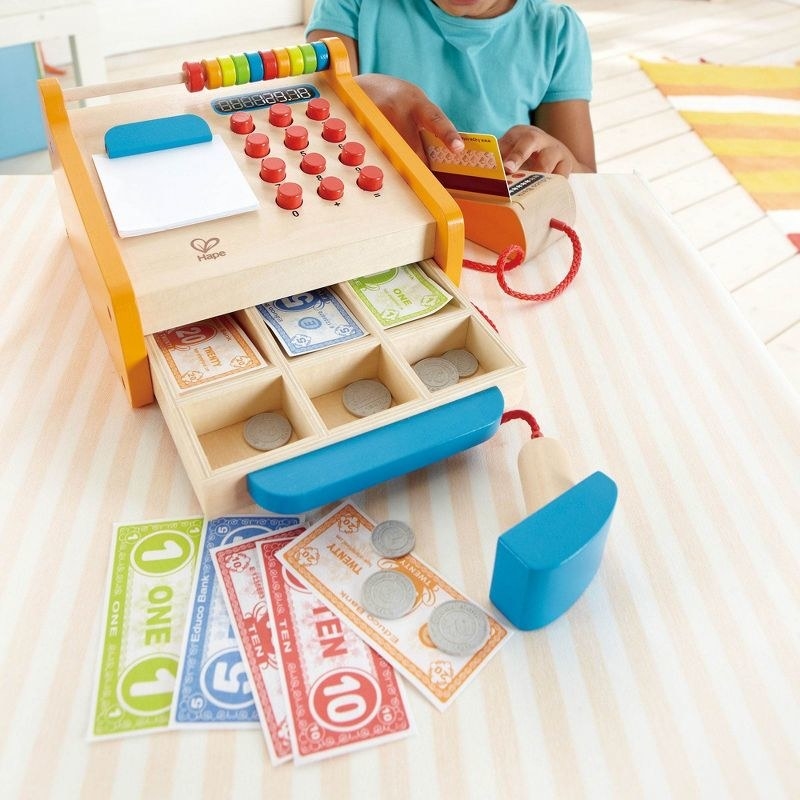 A child with a toy cash register