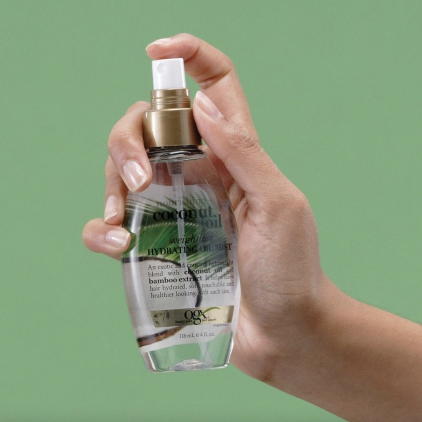 A person holding a small bottle of oil mist
