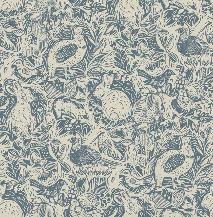 the blue and beige woodland creature patterned wallpaper up close