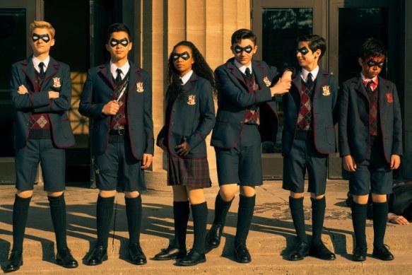 The Umbrella Academy as children standing in front of a ban after a battle; Ben is covered in blood and looks sad