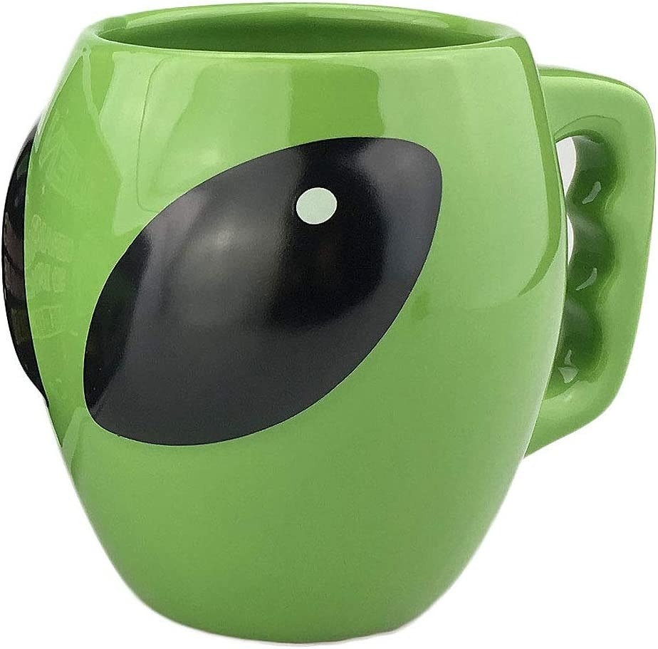 taza de color verde con diseño de cara de extraterrestre