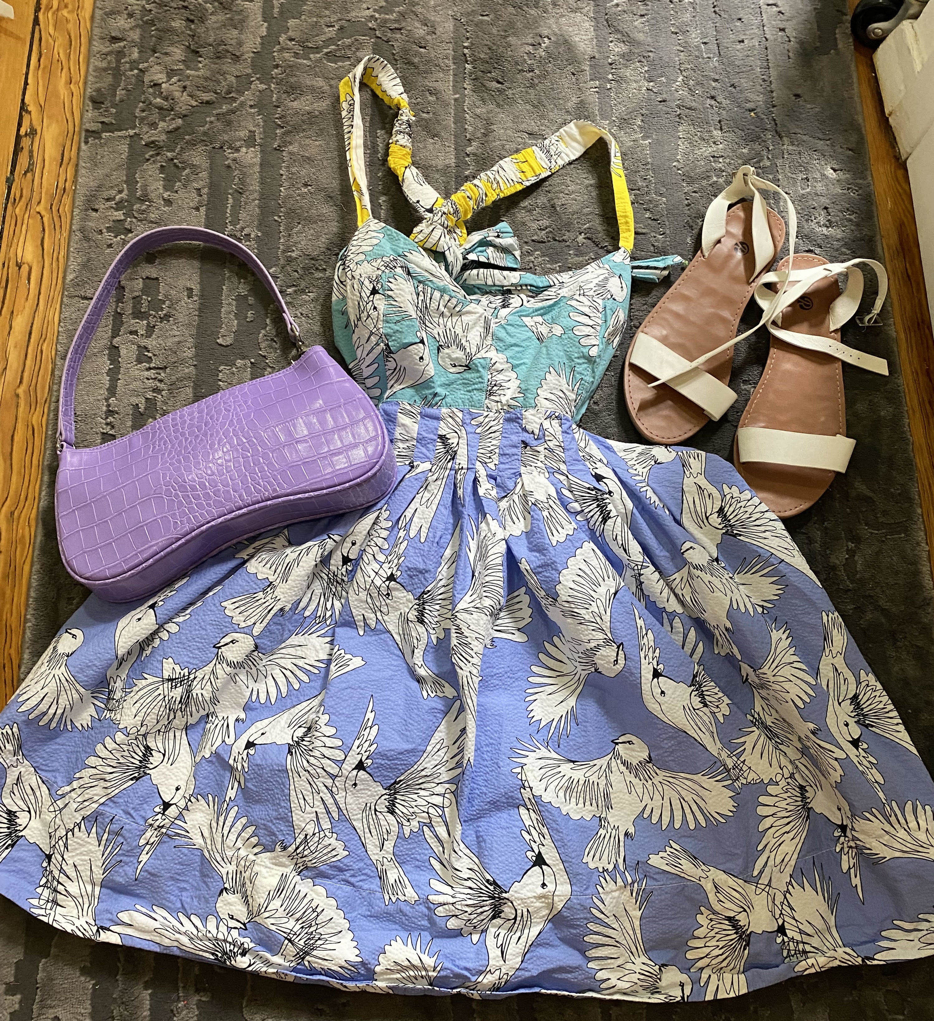 dress on floor with a purse and sandals beside of it