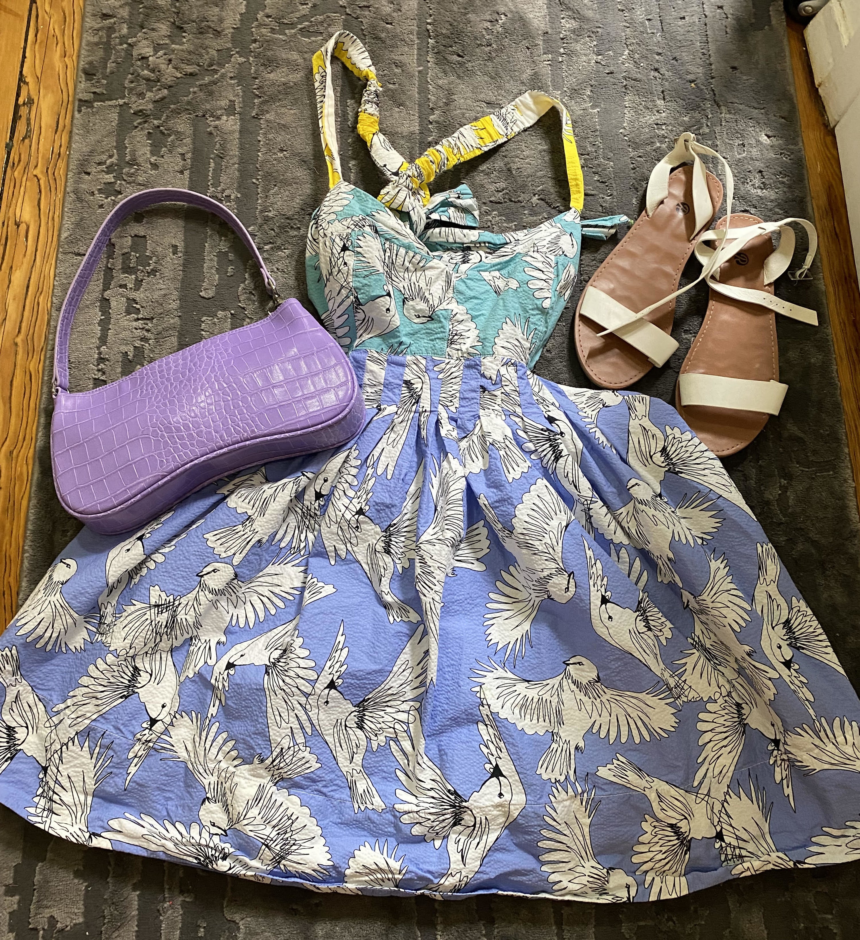 dress on floor with a purse and sandals beside of it