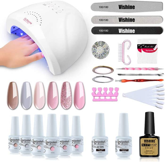 The LED lamp with a hand in it, nail colours, and nail tools