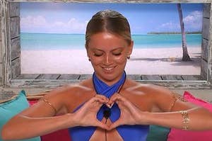 tasha from love island holds her hands in a heart