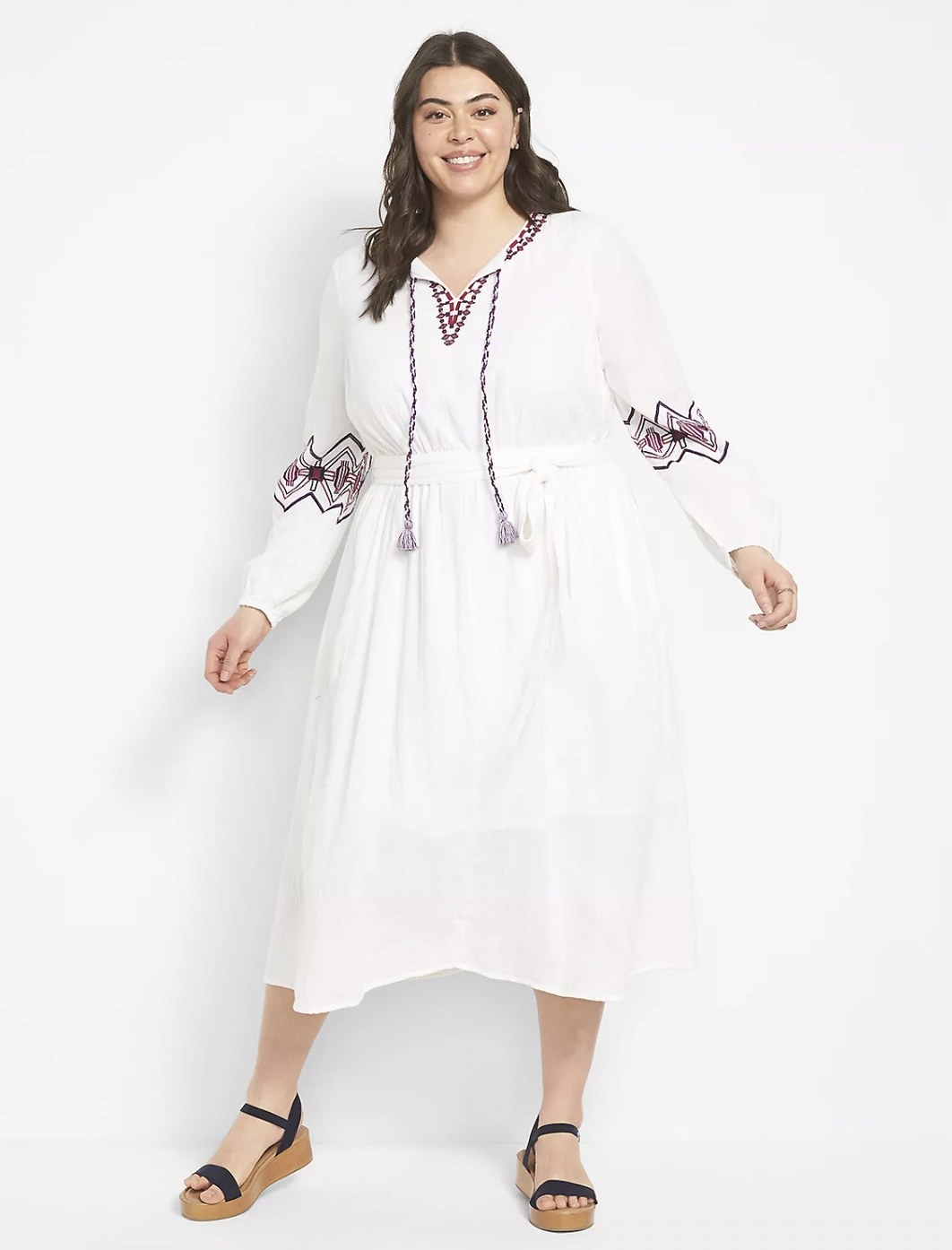 Model in the white long-sleeve dress featuring long tie front tassels