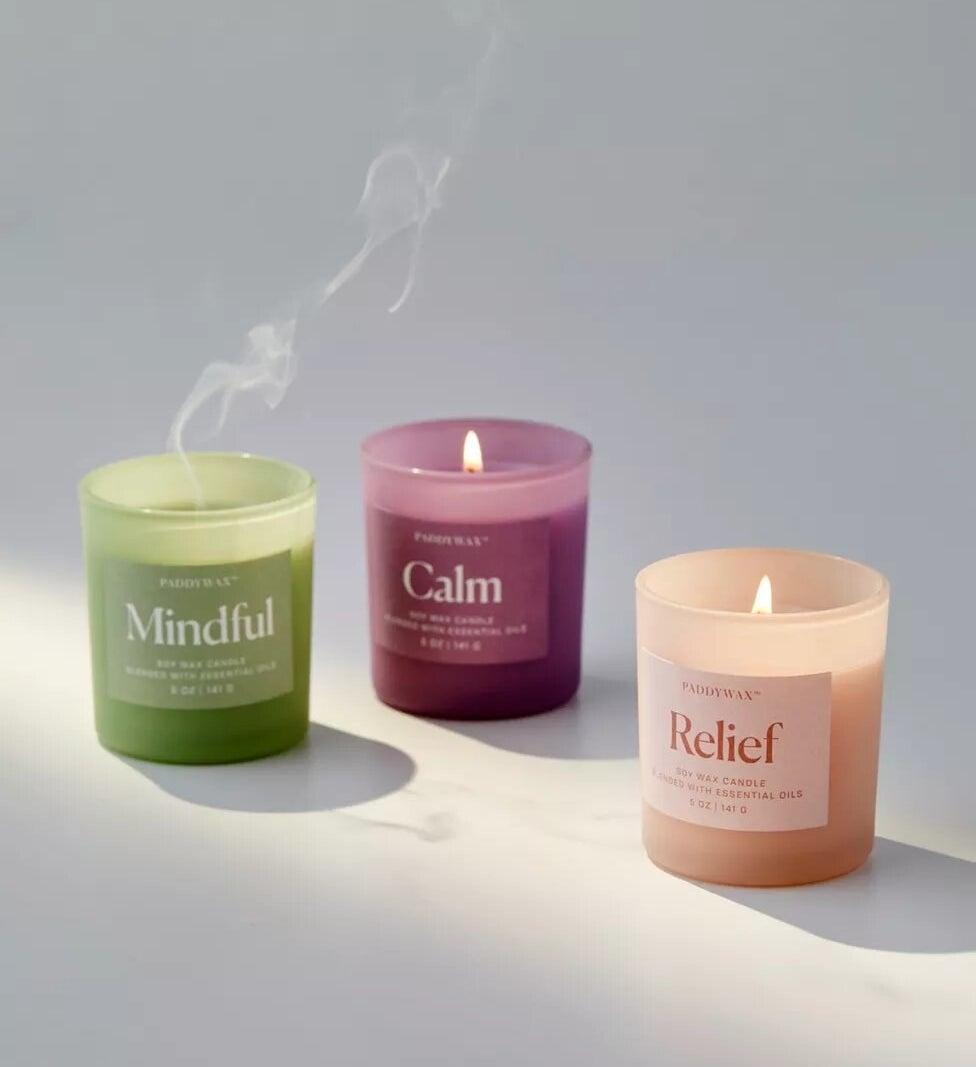 The three candles in the set burning against a plain background