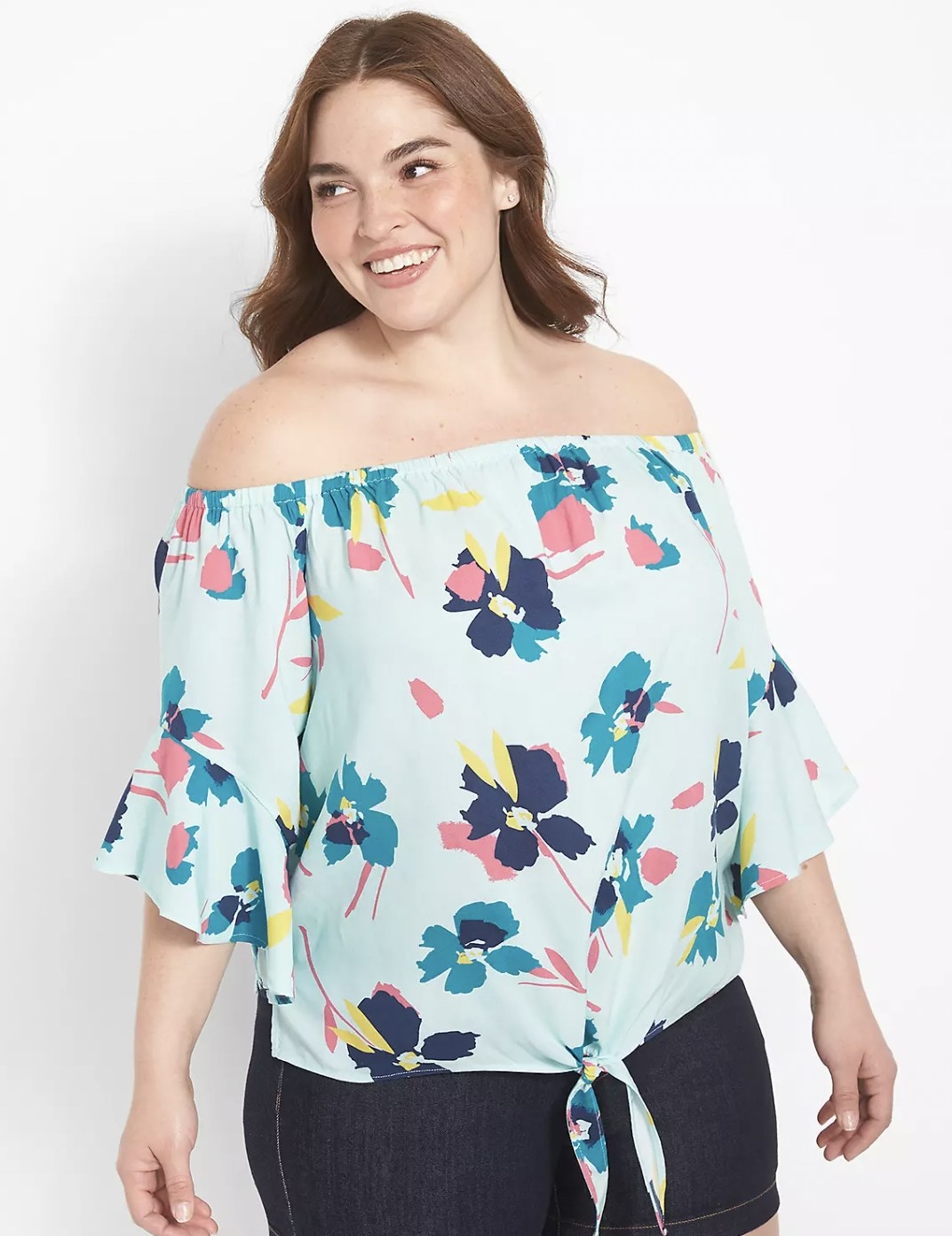 Model in the light blue with floral pattern top featuring tie-front detail at hem