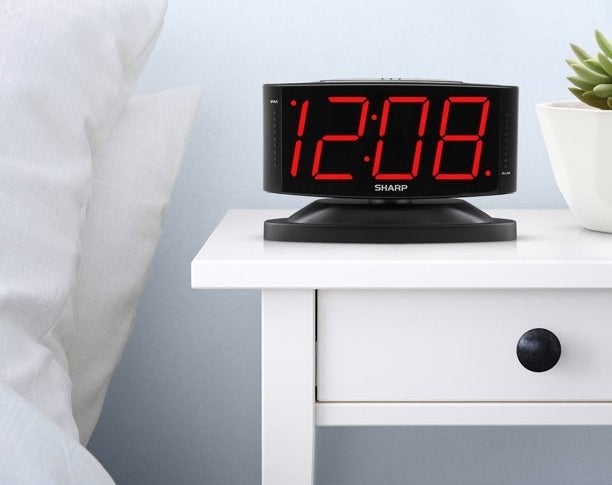 the black alarm clock on a nightstand
